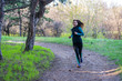 Young woman on a morning run through the spring forest.