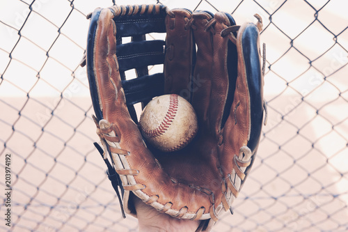 Fotografia, Obraz American sport of baseball shows closeup of ball in glove from dugout