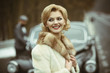 © Volodymyr - Wealthy couple near classic retro car on road.