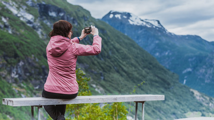 Poster - Tourist with camera looking at scenic view in mountains Norway