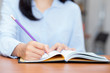© N_studio - Closeup hand of asian young woman writing on notebook on table, girl work at coffee shop, freelance girl with paperwork message on note, education concept.