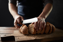 Grain Bread Put On Kitchen Wood Plate With A Chef Holding Knife For Cut