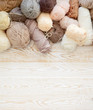 Wool and cotton yarn for knitting of neutral natural color. Background is aged white wood.