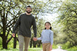 © LIGHTFIELD STUDIOS - father and daughter walking and holding hands in park