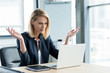© LIGHTFIELD STUDIOS - surprised businesswoman gesturing with hands and lookng at laptop in office