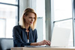 © LIGHTFIELD STUDIOS - smiling professional businesswoman working with laptop in office