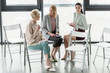 © LIGHTFIELD STUDIOS - professional businesswomen sitting on chairs and talking in office