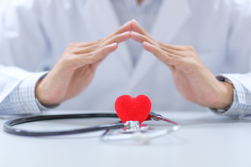 Male Doctor hand over stethoscope and red heart shape in the hospital. Healthcare and Healthy Insurance concepts