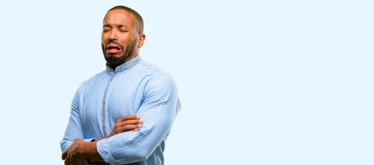 Canvas Print - African american man with beard crying depressed full of sadness expressing sad emotion isolated over blue background