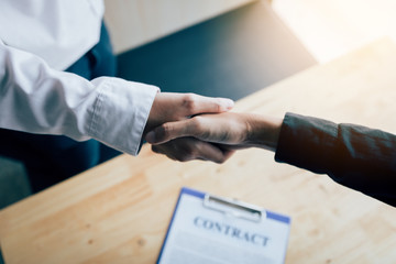 Wall Mural - Two people shaking hands with making a contract in the office.