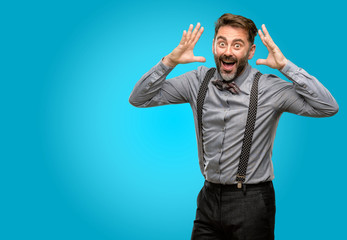 Canvas Print - Middle age man, with beard and bow tie happy and surprised cheering expressing wow gesture