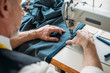 cropped image of tailor sewing cloth with sewing machine at sewing workshop