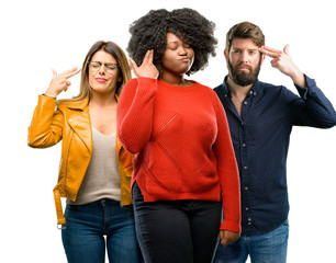 Wall Mural - Group of three young men and women unhappy making suicide gesture, tired of everything. Shoots with hand imitating gun, upset