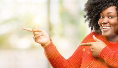 Poster - Beautiful african woman pointing away side with finger, outdoor