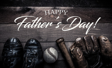 Wall Mural - A group of vintage baseball equipment, bats, gloves, baseballs on wooden background with a father's day greeting