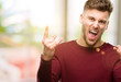 © Krakenimages.com - Handsome young man making rock symbol with hands, shouting and celebrating