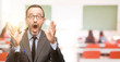 © Krakenimages.com - Teacher man using glasses stressful keeping hands on head, terrified in panic, shouting at classroom