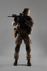 Wall Mural - Soldier in camouflage holding rifle