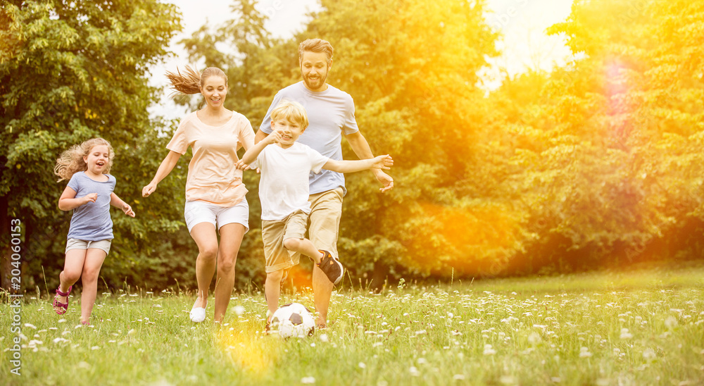 Familie und Kinder spielen Fußball im Garten - obrazy, fototapety, plakaty 