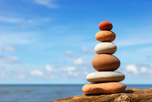 Rock Zen Pyramid Of White And Pink Stones On A Background Of Blue Sky And Sea.