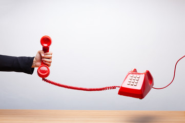 Business woman holding the red phone