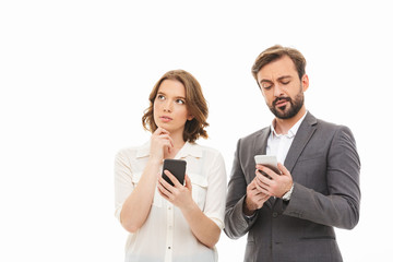 Canvas Print - Portrait of a pensive business couple holding mobile phones