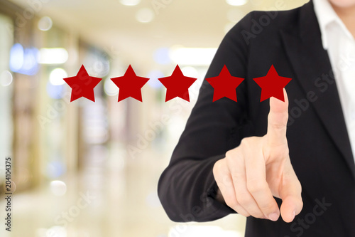 Fotografía Businesswoman hand pointing red five star over blur background, customer excelle
