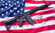 Custom built AR-15 carbine and bullets on American flag surface, background. Studio shot.