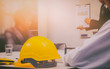 © catacartphoto - Yellow hard hat on construction site background blurred Businessman team