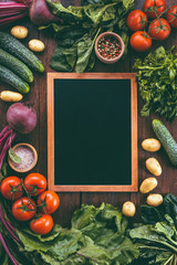 chalk board on a wooden background surrounded by vegetables, food frame, menu design, vegetables on a wooden table