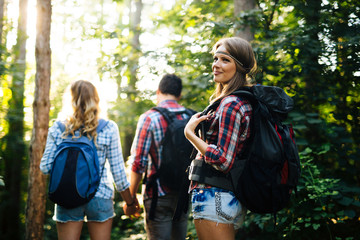Wall Mural - beautiful woman and friends hiking in forest