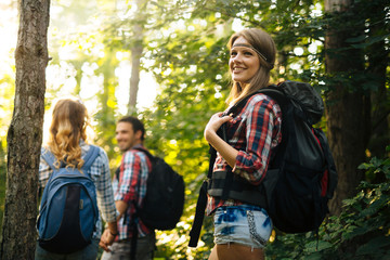 Wall Mural - group of backpacking hikers going for forest trekking
