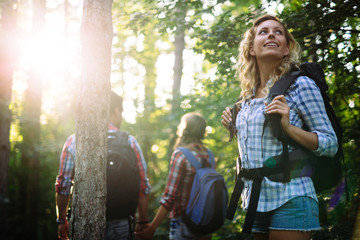 Wall Mural - group of backpacking hikers going for forest trekking
