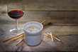 potted blue stilton cheese in a ceramic jar, port wine and some nibble sticks on a dark rustic wooden table, copy space