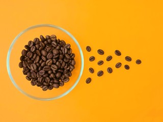 Cup with coffee beans on an orange background.