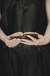 woman hands holding vintage old book, very dark atmospheric sensual rural, gothic studio shot can be used as background