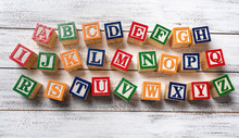 Multi-colored Wooden Letter Blocks Making The Alphabet On White Wood Background