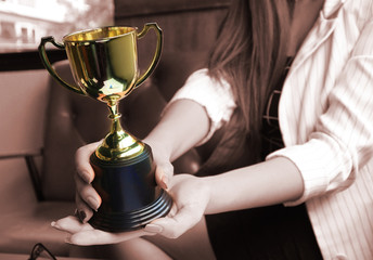 Wall Mural - trophy hold on working women 's hands, win concept.