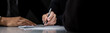 © Atstock Productions - Businessman signing contract at the table in dark room, panoramic banner background with copy space