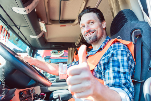 Cuadros en Lienzo Truck driver man sitting in cabin giving thumbs-up