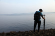 © Rahul - Silhouette of the photographer with tripod. Young man taking photo with his camera in the morning near lake. In india