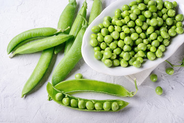 Shelled and unshelled peas on white plaster background. Top view