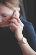 © Przemek Klos - Woman talking on mobile phone wearing pink gold wristwatch with bracelet and blue dress
