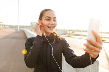 Wall Mural - Happy young asian sports woman talking by mobile phone.