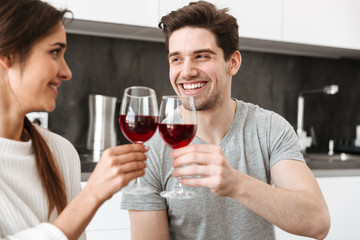 Poster - Portrait of a happy young couple holding glasses of wine