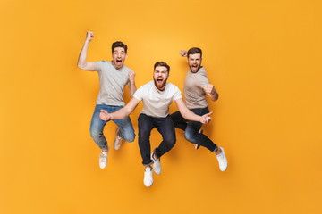 Wall Mural - Three young happy men jumping together