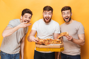 Wall Mural - Three young happy men eating big pizza