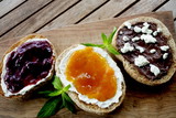Fototapeta  - Homemade Chocolate-Hazelnut Spread with cream cheese and apricot, strawberry jam on bread. Wood background.