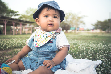 Cute little asian baby sitting in garden,vintage ton