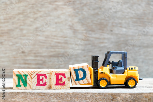 Fotografie, Obraz Toy forklift hold letter block D to complete word need on wood background